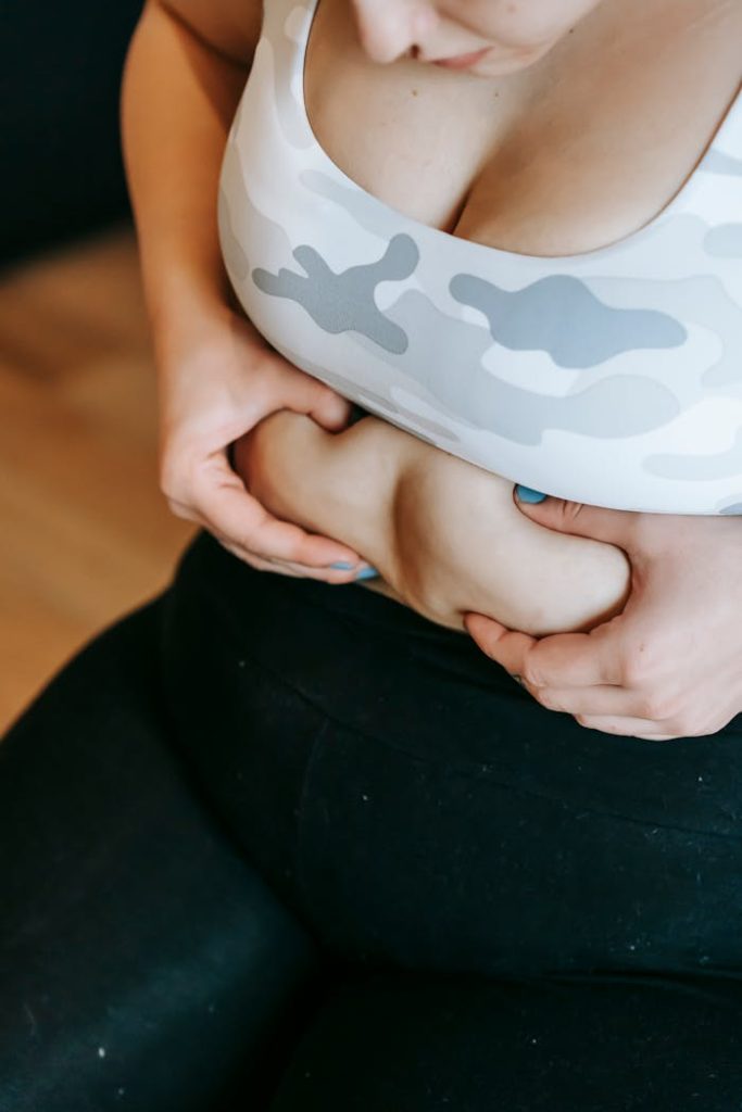 Close-up of a woman embracing her body during a workout in the gym.